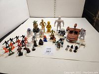 Overall lot of Star Wars figures laid out showing variety of characters, vehicles, and miniatures