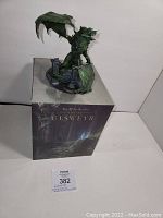 Dragon statue on top of the original box showing the overall product and condition including minor wing damage.