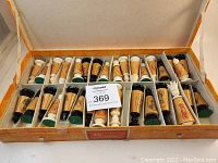 Full set of 32 carved and etched chess pieces in black and natural colors arranged inside original compartmentalized orange case.