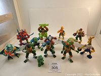 Front view showing group of TMNT and allied mutant action figures with medium lighting and plain background.