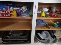 Overview photo showing shelves with baking pans, food wraps, food storage containers, strainers, and kitchen utensils.