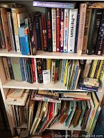 Shelf of assorted books including historical, psychological, and reference titles along with some cookbooks and dictionaries