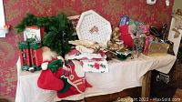 Photo of table with assorted Christmas holiday decorations: ribbons, stockings, nutcrackers, greenery, and figurines