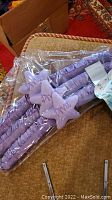Photo of padded lavender hangers with star-shaped decorations still in plastic wrapping.