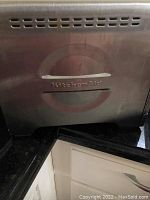 Close-up of KitchenAid toaster oven front with logo and stainless steel finish.