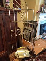 Full view of metal shelf unit, fireplace tools on stand, and log holder.