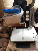 Dell printer and various office supplies including receipt rolls, file keepers, paper cutter, and clipboard
