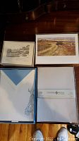 Photo showing boxed greeting cards with landscape artwork and envelopes with a horse sketch design