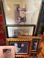 Photo showing six framed artworks stacked, including one with ballet bears with visible water stain on upper right side