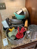 Full lot including bundt pan, bread pans, pie pan, colander, rolling pin, grater, flour sifter, and sets of measuring cups.