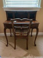 Desk and chair set photographed from behind showing chair back and desk top compartments