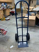 Full dolly showing blue metal frame, two black wheels, and flat base plate