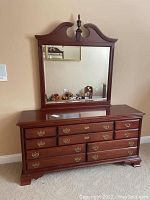 Full view of dresser with attached mirror showing traditional design and reddish-brown wood finish