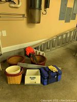 Grouped items including two ceramic flower pots, a white plastic trashcan, wicker basket, coolers, and gutter guards.