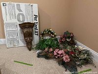 Pet Yard XT pet fence box with an ornate wall hanging pedestal leaning on it and faux flower arrangements laid on the floor nearby.