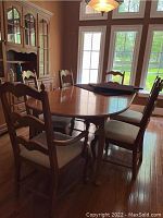 Full view of dining table with six chairs around it near window