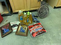 Photo of tiki torch fuel, metal hose caddy, swim goggles with snorkels and raceway seat pad, plus two framed mirrored Lake Placid 1980 Olympics wall hangings.