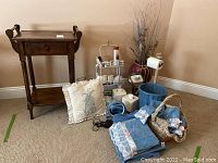 Primary photo shows entire lot with wood washstand, decorative pillow, towels in wicker baskets, trash bin, flower vase, shower caddy, and bathroom accessories arranged on carpet.