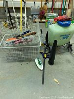 Wide view showing wire mesh storage baskets, SP Systems sprayer, Irwin Quick Grip clamp, and garden hand tools.