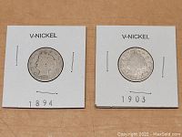 Two V-Nickel coins dated 1894 and 1903 in white cardboard holders labeled accordingly.