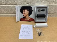 Heyday earbuds in original packaging with charging case, user manual, and spare ear tips laid out on table.