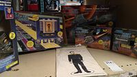 Star Trek toy collection on table showing boxed Transporter, Phaser Walkie Talkie, figurine in packaging, and two Tricorder boxes without contents.