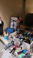 Box containing various 4.75 inch Star Trek figures, Mickey holiday mug, Minnie Mouse rubber bank, Kingdom Hearts keys, chipmunk figures, and fashion doll, showing multiple items piled together.