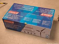 Top of blue Coleman box showing product name and wattage