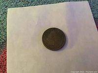 Photo of the front side of 1911 Liberty Head Nickel coin, showing the silhouette and date.