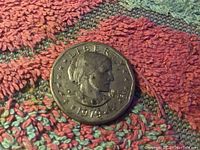 Top side of a 1979 Susan B Anthony dollar coin showing profile portrait, date and 'LIBERTY' inscription.