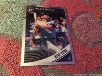 Front side of the 2018 Mickey Mantle baseball card, showing the player mid-swing with vibrant design elements, bearing the Donruss Optic logo and 'New York' designation.
