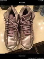 Top view of Air Jordans showing toe box and laces, displaying metallic leather surface with crease marks.