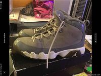 Side view of grey Air Jordan Retro 9 sneakers showing detailed texture and sole.