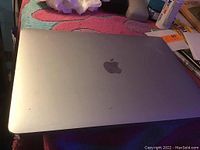 Closed silver Apple MacBook Pro laptop showing top cover with Apple logo and minor wear.