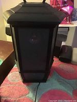 Front view of the black Bluetooth lantern speaker showing the mesh grill and lantern design.