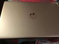 Top view of silver HP laptop closed, showing HP logo on lid.