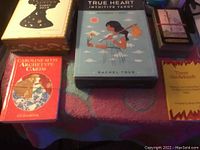 Photo of several tarot card decks and books arranged on a surface, showing titles like True Heart Intuitive Tarot, Jacqueline Myss Archetype Cards, and a yellow Tarot Guidebook.