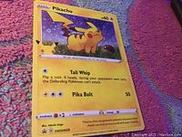 Photo of front of 2020 Basic Pikachu Pokémon card #60 featuring Tail Whip and Pika Bolt attacks, showing condition and details.