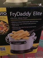 Box of Presto FryDaddy Elite electric deep fryer showing product details and frying basket filled with crinkle-cut fries.