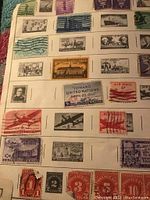 Close-up of vintage postage stamps on album page, including U.S. and airmail issues