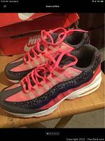 Photo of left shoe front and side showing pink, grey, navy and cream color scheme with pink laces and Air Max cushioning soles