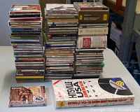 Overview photo of the 85 CDs stacked in four columns showing various jewel case spines and box sets including Hitsville USA and classical music.