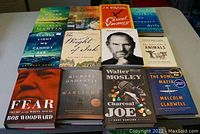 Photo showing all 12 hardcover books arranged in three rows on a white surface, titles clearly visible.