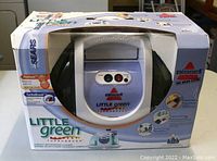 Front view of the unopened Bissell Little Green ProHeat Turbobrus box showing product inside.