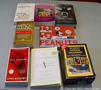 Photo of nine book titles and a boxed National Geographic DVD set, arranged on a flat surface.