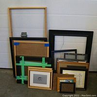 Set of 19 assorted picture frames stacked against a white background, showing variety of materials and sizes, some with glass and backing.