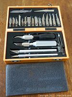 Overview of softwood carving kit inside wooden case showing all blades and blade holders.