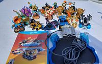 Wii U game, Skylanders portal, and multiple Skylanders figurines arranged on white background
