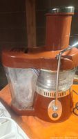 Photo of SPA FREE orange Fusion Juicer with metal latch and BPA Free label