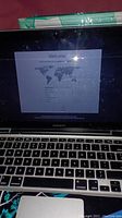 Apple MacBook Pro laptop with screen showing setup welcome page and keyboard view